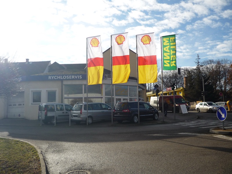 Parkoviště autoservisu Pelhřimov s vlajkami Shell